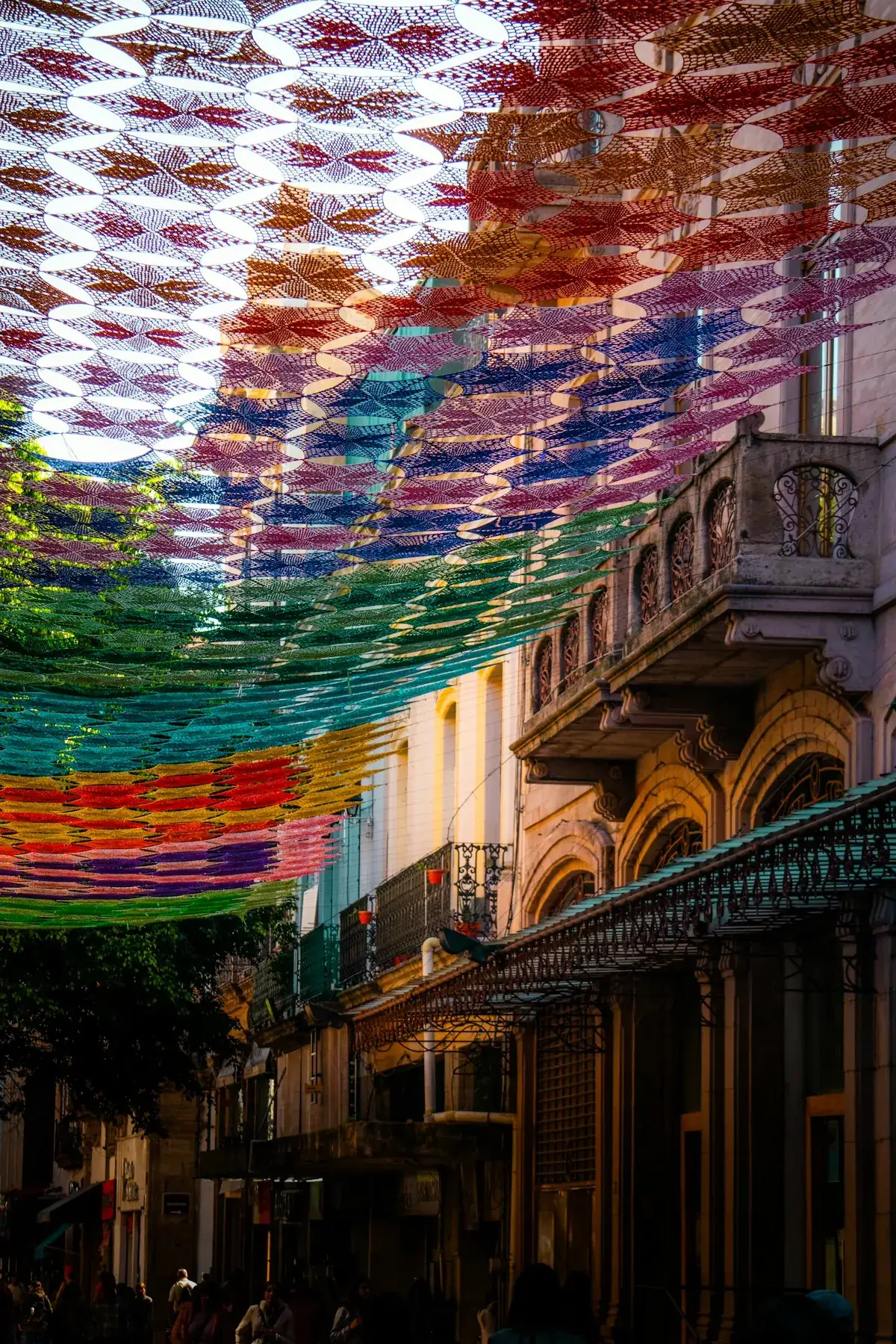 Calle con papel picado de colores colgando sobre las fachadas